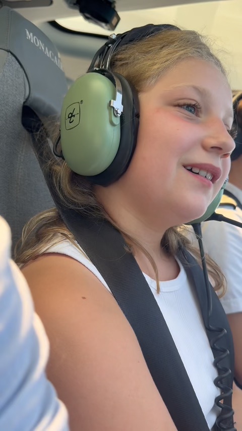 Mathilde wearing a headset in the helicopter